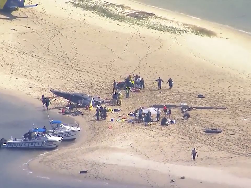 This image made from a video shows sand island island with crashed helicopter, victims and emergency services on Gold Coast, Australia Monday, Jan. 2, 2023. Two helicopters collided in the Australian tourist hotspot Monday afternoon. (CH9 via AP)