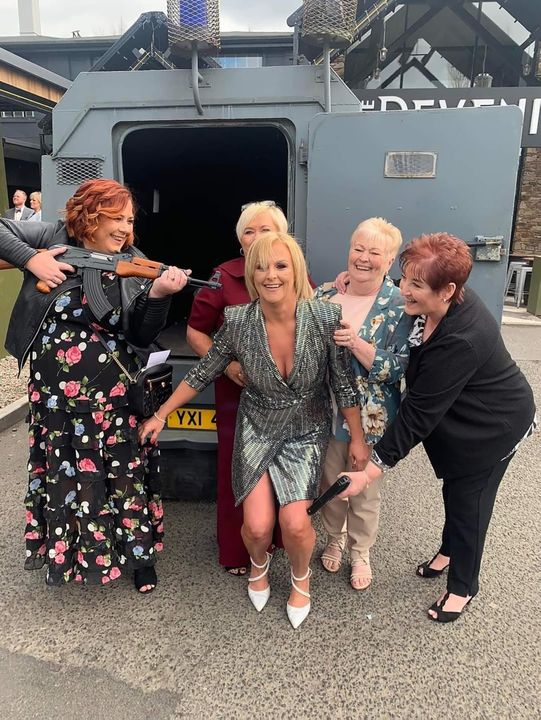 Guests at the wedding of Maunuel Fryers to Brenda Smith pose with fake hand guns beside a former RUC Land Rover, which was used as the wedding car
