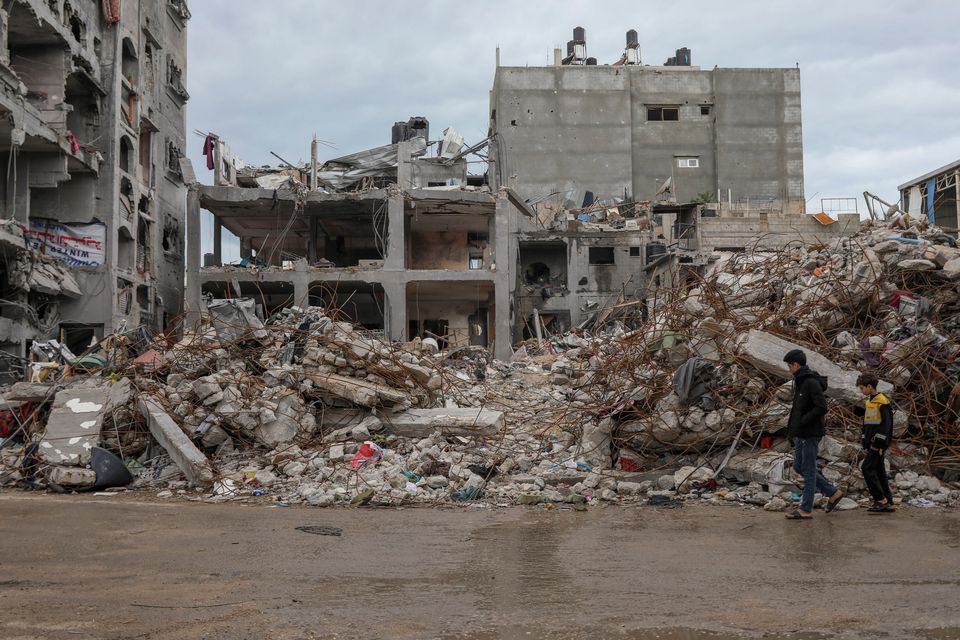 Palestinians walk by a destroyed building in Gaza's Jebaliya refugee camp as the ceasefire continues. Photo: AP