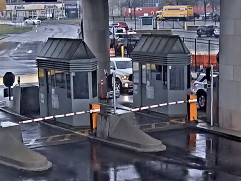 In this photo taken from security video, a light colored vehicle, top left, travels toward the Rainbow Bridge customs plaza, Wednesday, Nov. 22, 2023, in Niagara Falls, N.Y. A vehicle exploded at a checkpoint on the American side of a U.S.-Canada bridge in Niagara Falls Wednesday, leaving two people dead and prompting the closing of four border crossings in the area, authorities said. (Customs Border Protection via AP)