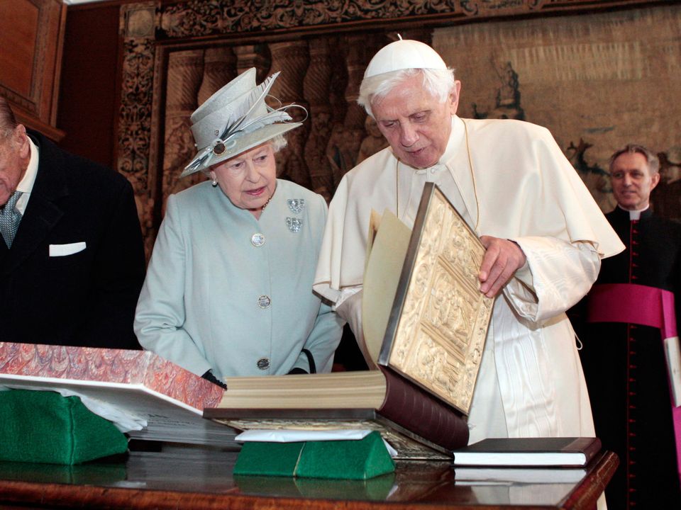 The Duke of Edinburgh looking on (left) as Queen Elizabeth II talks with Pope Benedict XVI.
Photo:  PA