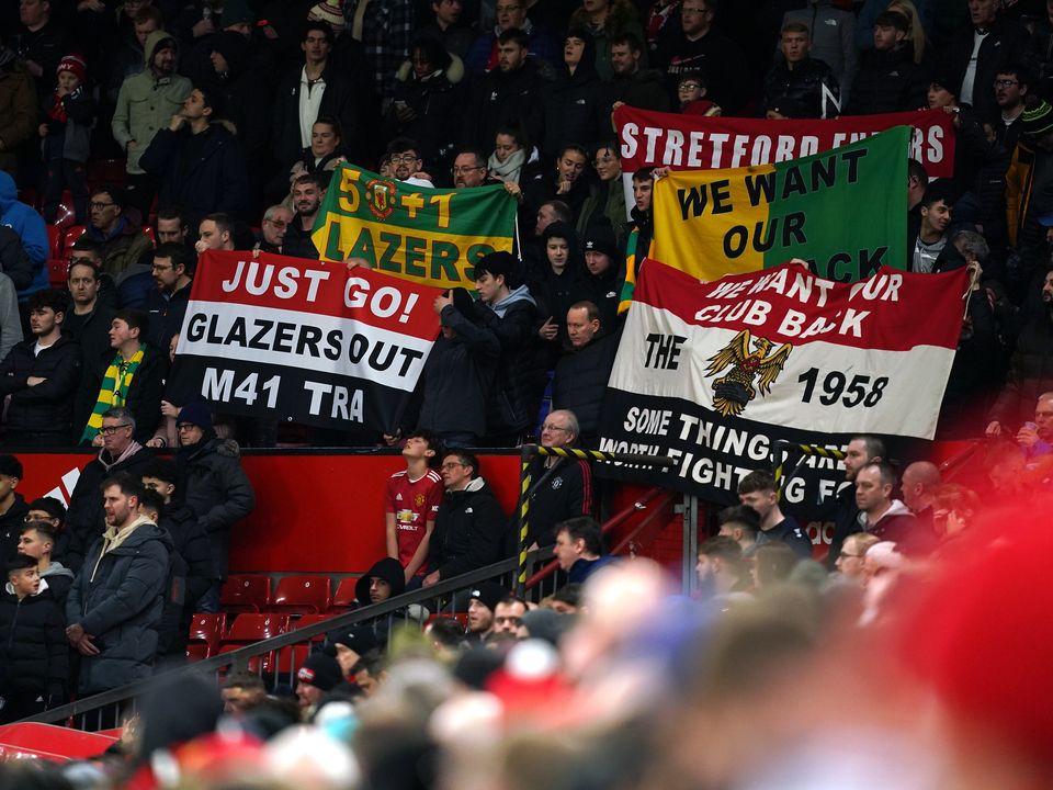 Manchester United fans in the stands hold up flags in protest against the Glazers during the Carabao Cup Quarter-Final match at Old Trafford, Manchester. Picture date: Tuesday January 10, 2023.