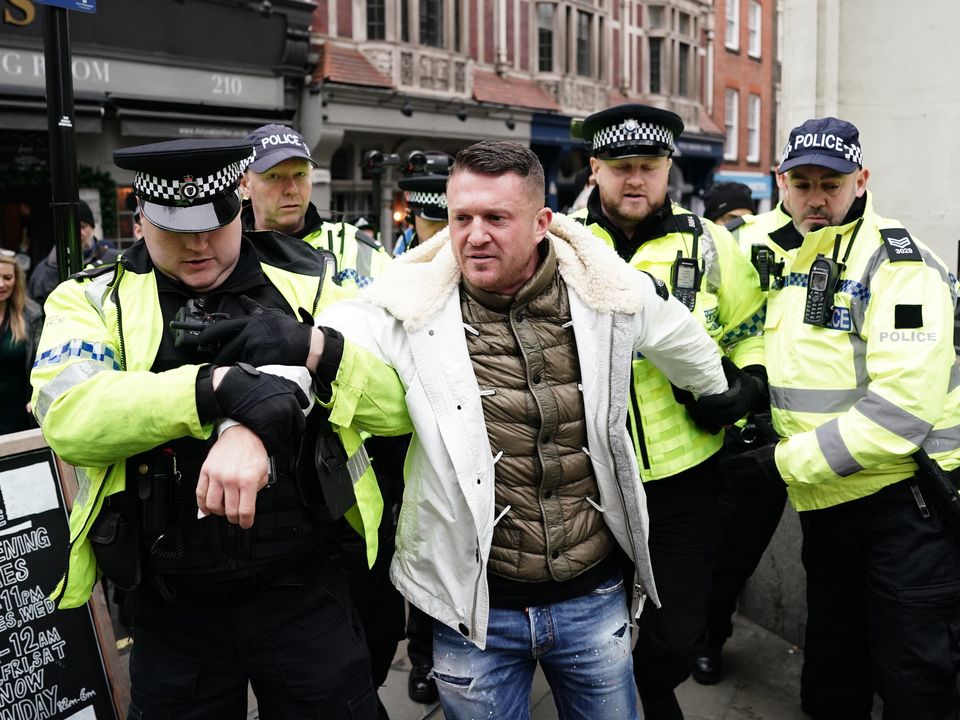 Tommy Robinson is led away by police officers as people take part in a march against antisemitism in London (Jordan Pettitt/PA)