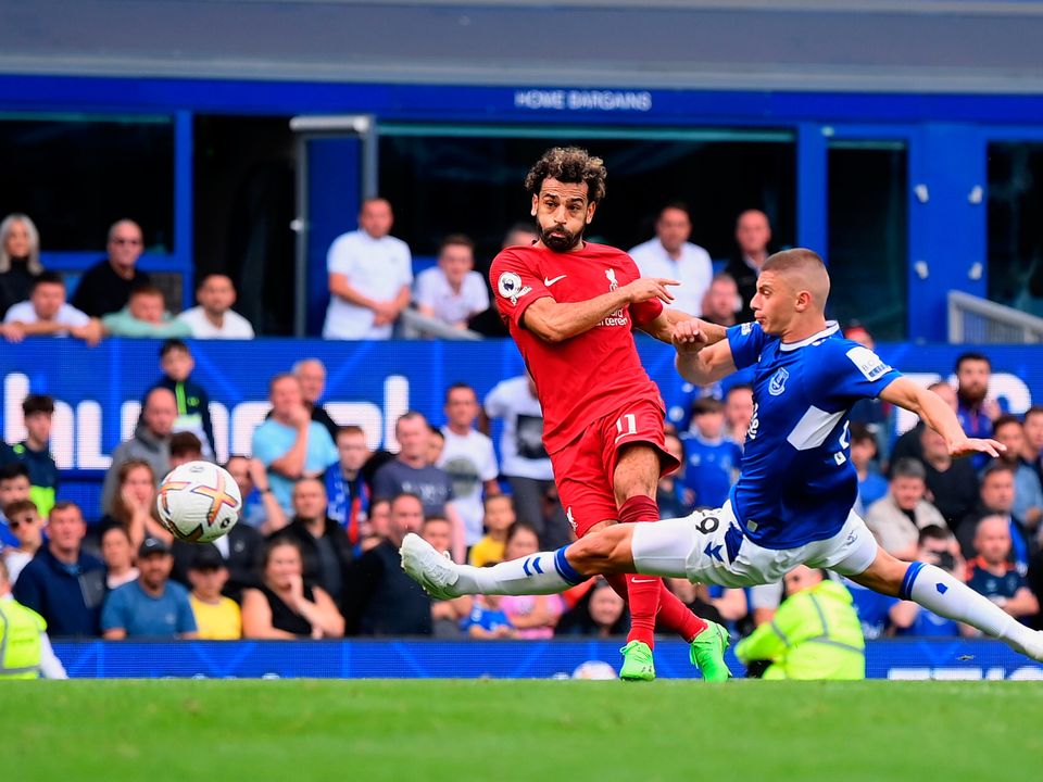 LIVERPOOL, ENGLAND - SEPTEMBER 03: Mohamed Salah of Liverpool is challenged by Vitaliy Mykolenko of Everton as their shot hits the post during the Premier League match between Everton FC and Liverpool FC at Goodison Park on September 03, 2022 in Liverpool,