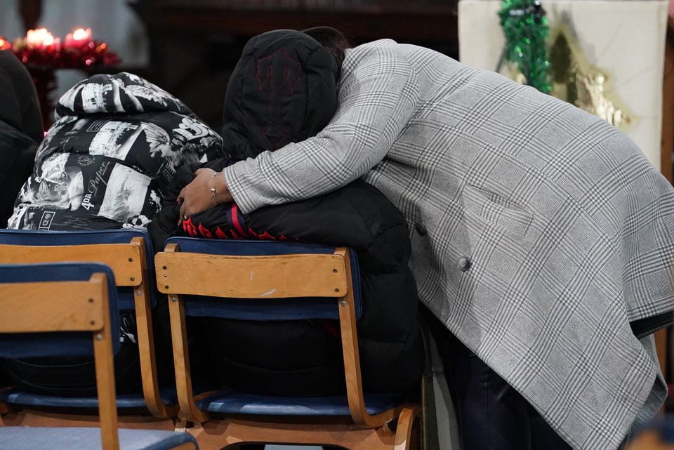 People embrace during a vigil at St. Mary Magdalene Church