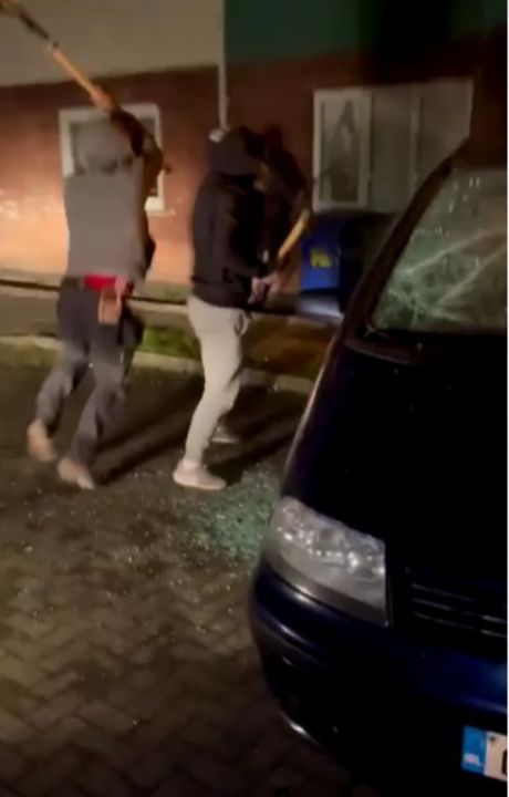 Footage of a group of men armed with slash hooks smashing up a car