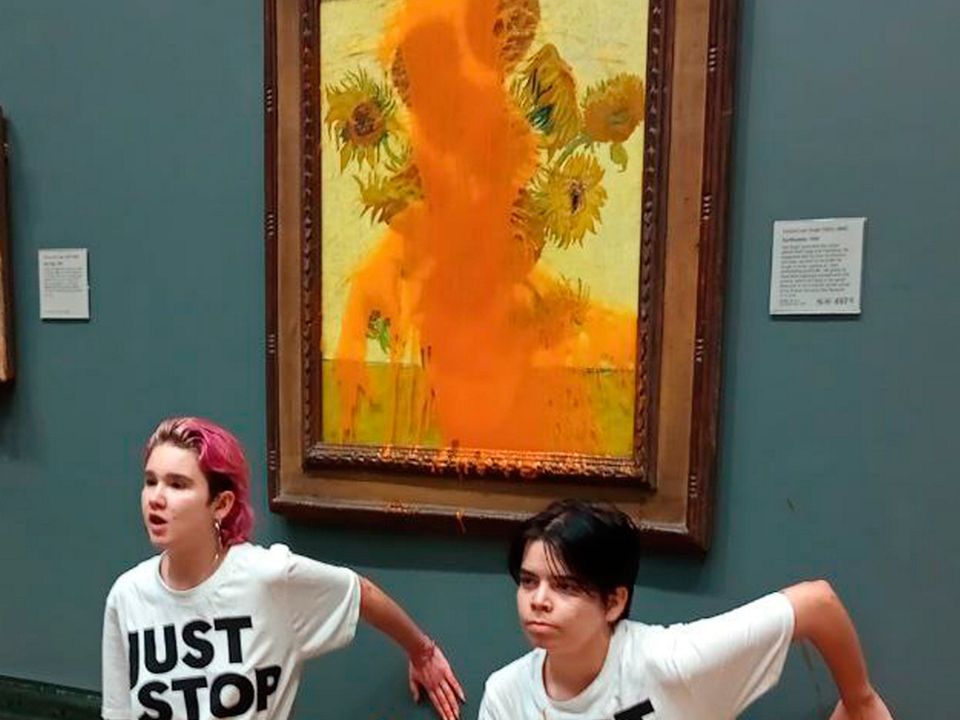 Handout photo issued by Just Stop Oil of two protesters who have thrown tinned soup at Vincent Van Gogh's famous 1888 work Sunflowers at the National Gallery in London. Picture date: Friday October 14, 2022. PA Photo. See PA story PROTEST Oil. Photo credit should read: Just Stop Oil/PA Wire 

NOTE TO EDITORS: This handout photo may only be used in for editorial reporting purposes for the contemporaneous illustration of events, things or the people in the image or facts mentioned in the caption. Reuse of the picture may require further permission from the copyright holder. 