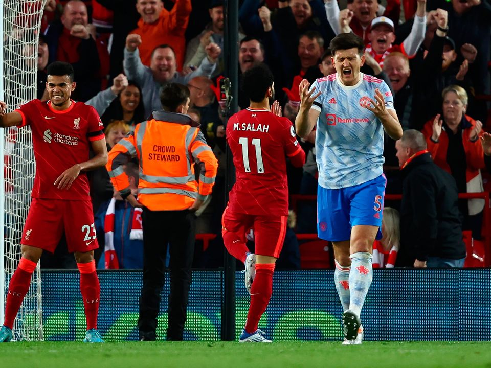 Harry Maguire of Manchester United reacts whilst Mohamed Salah of Liverpool celebrates scoring their side's second goal at Anfield. (Photo by Clive Brunskill/Getty Images)