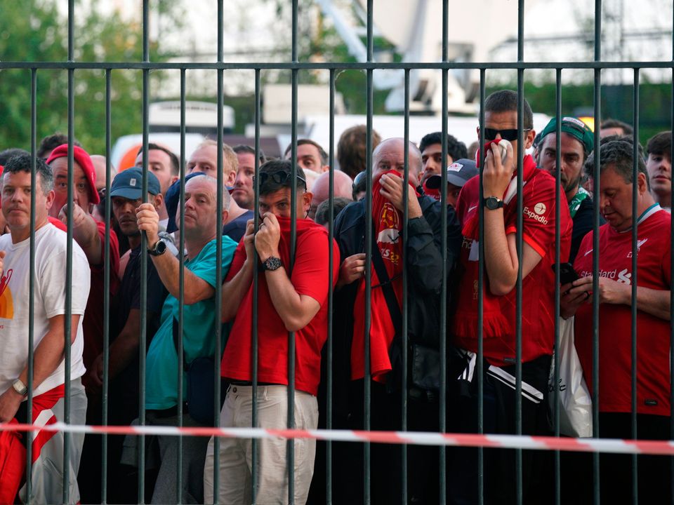 Liverpool fans cover their mouths and noses as they queue to gain entry to the stadium as kick-off is delayed ahead of the Champions League final at the Stade de France last May. Photo: PA/Reuters