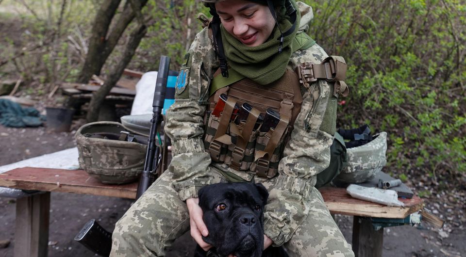A Ukrainian service member pets a dog at a position, as Russia’s attack on Ukraine continues, in Donetsk Region. Picture: Reuters