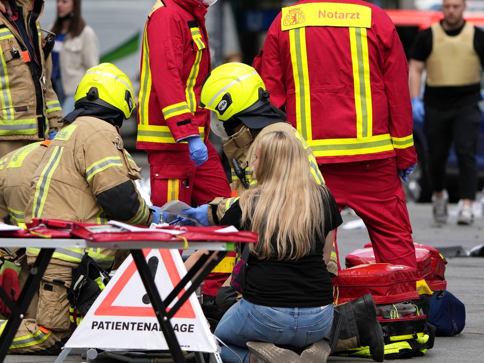 Rescue workers help an injured person after a car hit a crowd of people in central Berlin (Michael Sohn/AP)