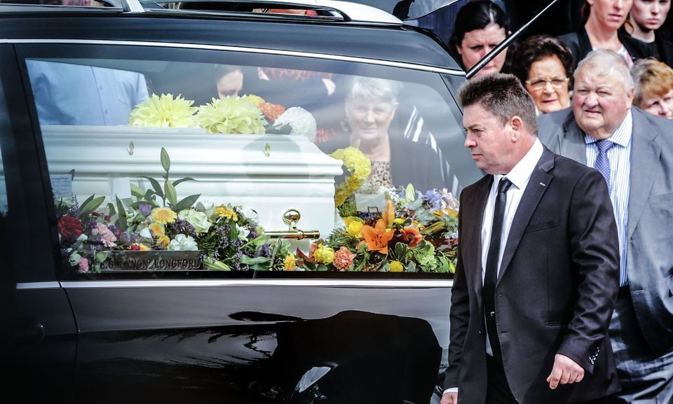 Michael Dennany looks on the coffin with his children Mikey and Thelma at their joint funeral last year. Photo: Gerry Mooney