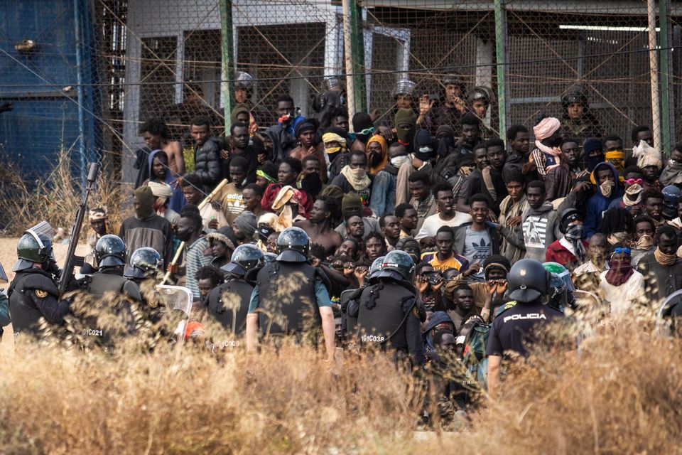 Riot police officers cordon off the area after migrants arrive on Spanish soil and crossing the fences separating the Spanish enclave of Melilla from Morocco in Melilla, Spain, Friday, June 24, 2022. (AP Photo/Javier Bernardo)
