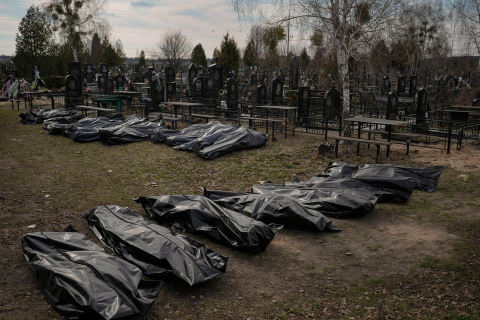 Bodies retrieved by municipal workers from the town are placed on the ground at a cemetery in Bucha, Ukraine, Thursday, April 7, 2022. (AP Photo/Vadim Ghirda)