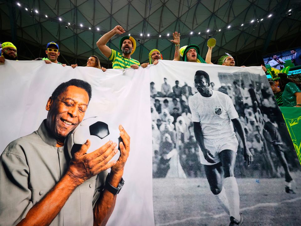 Brazil fans unveil a flag of in honour of Pele ahead of World Cup game against Cameroon
