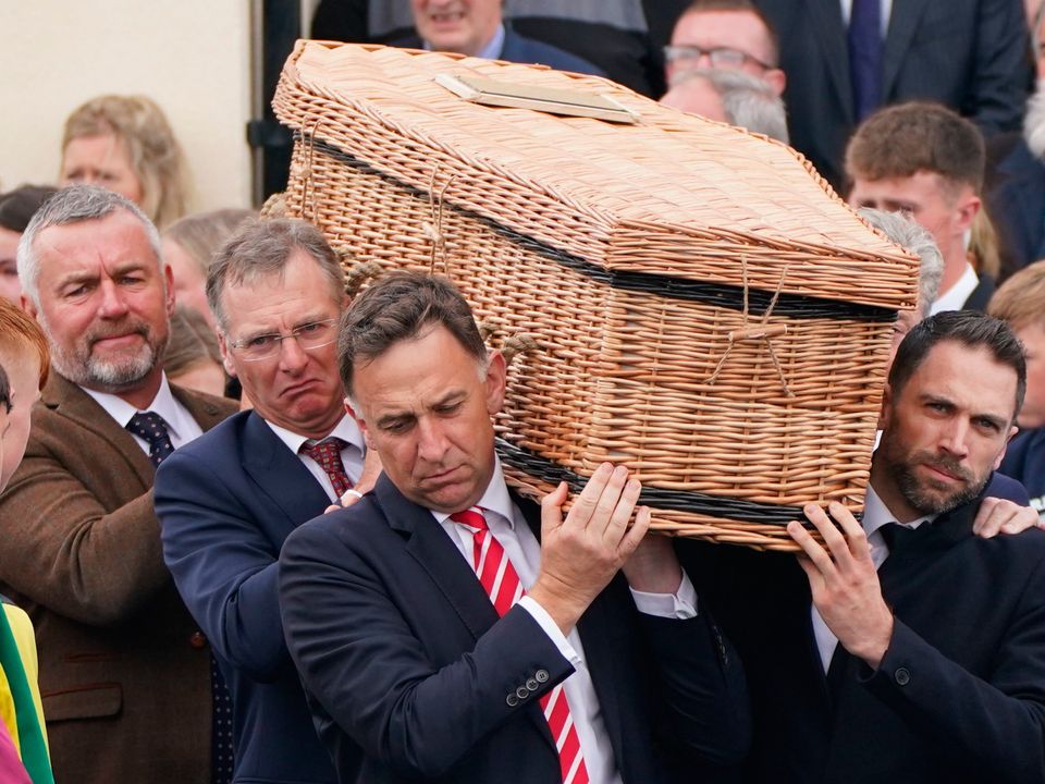Trainer Henry de Bromhead (left), father of Jack de Bromhead carries his son coffin after the funeral service 