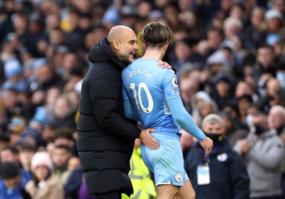 Manchester City's Jack Grealish (right) greets manager Pep Guardiola after he is substituted during the Premier League match at the Etihad Stadium, Manchester. Picture date: Saturday December 11, 2021.
