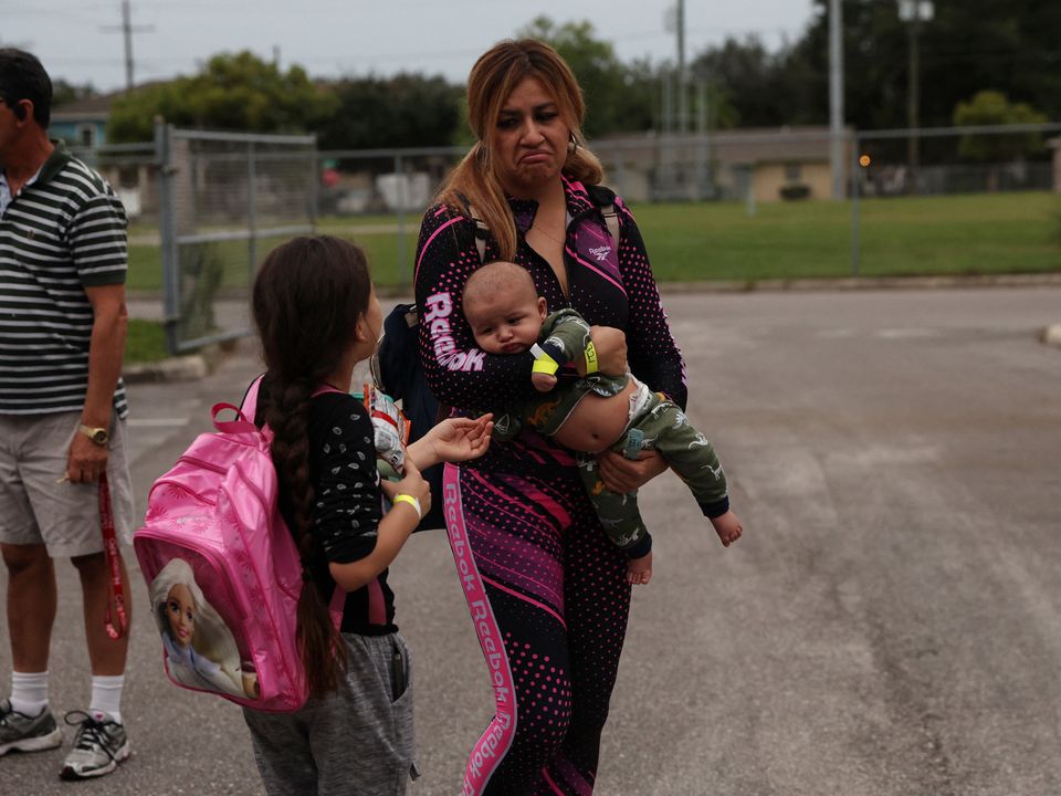 A woman holding a baby enters a shelter for evacuees in Tampa Bay, Florida. Reuters