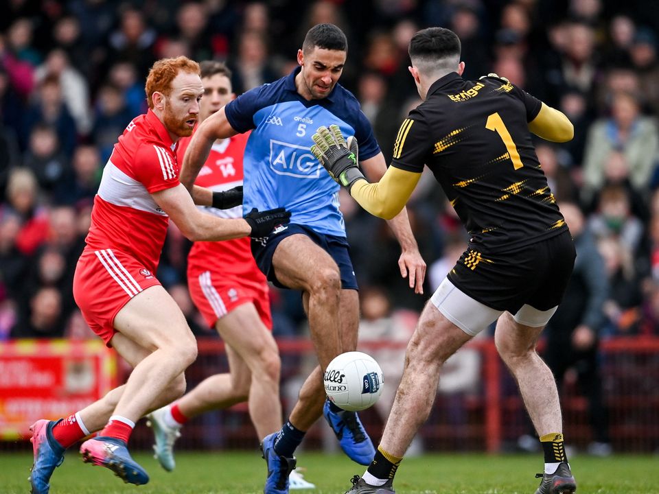 James McCarthy of Dublin shoots at goal under pressure from Derry players Conor Glass, left, and goalkeeper Odhran Lynch. Photo: Ramsey Cardy/Sportsfile