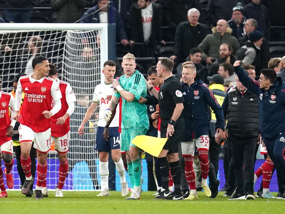 Arsenal goalkeeper Aaron Ramsdale speaks to the assistant referee after an attempt by a fan to kick him