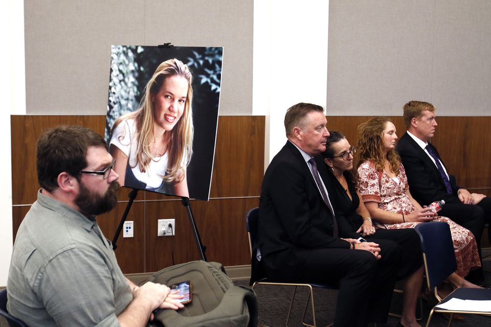 Chris Lambert, documentary podcaster, sits in front of a poster of Kristin Smart with family members nearby after a jury found Paul Flores guilty of her murder (Laura Dickinson/The Tribune/AP)