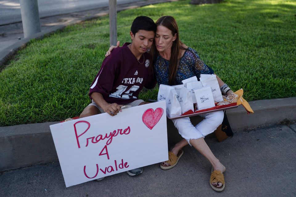 Diego Esquivel, left, and Linda Klaasson comfort each other as they gather to honor the victims killed in Tuesday's shooting at Robb Elementary School in Uvalde, Texas, Wednesday, May 25, 2022. (AP Photo/Jae C. Hong)