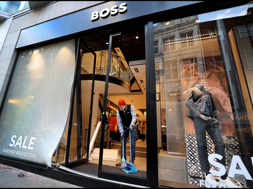 A worker helps clean up the damage at the Hugo Boss store on Grafton Street which was ram-raided early yesterday morning. Photo: Steve Humphreys