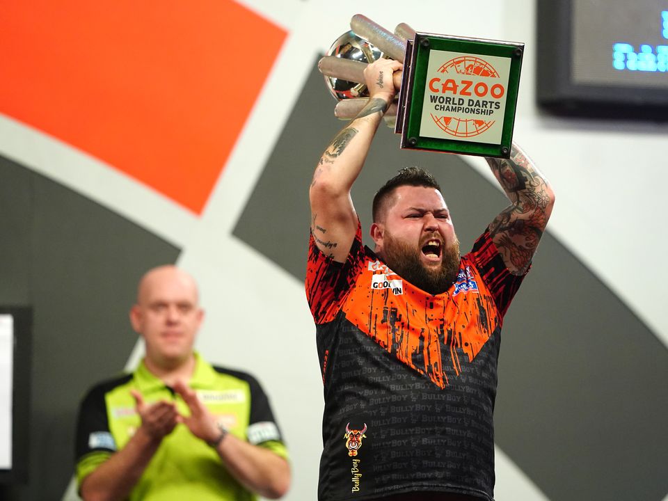 Michael Smith celebrates with the Sid Waddell trophy after winning the final of the Cazoo World Darts Championship against Michael van Gerwen