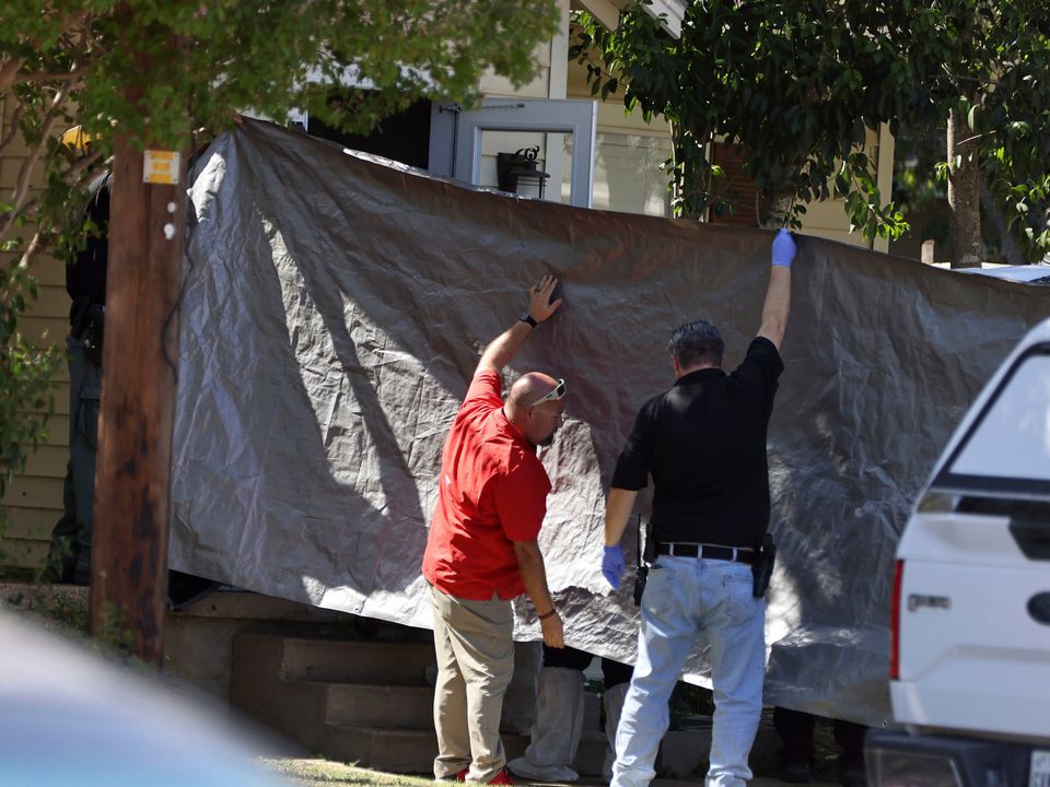 Law enforcement officers use a tarp to block the view as one of five bodies are removed from a house in McGregor, Texas Photo: Rod Aydelotte/Waco Tribune-Herald via AP
