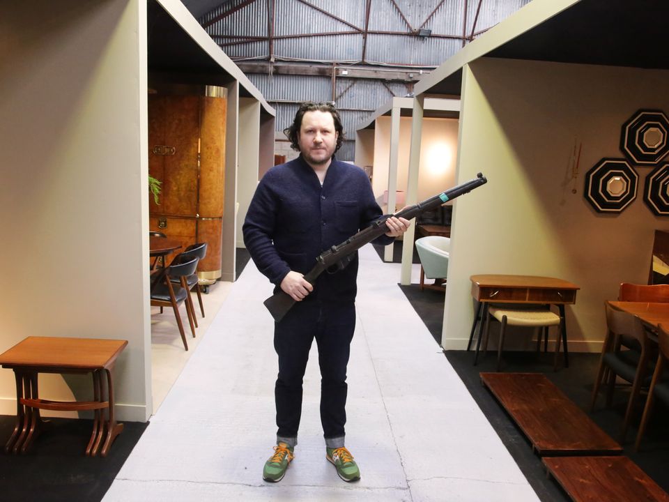 Killian McNulty of Historic Interiors with a prop rifle used in the 1996 film Michael Collins (Niall Mullen/PA)
