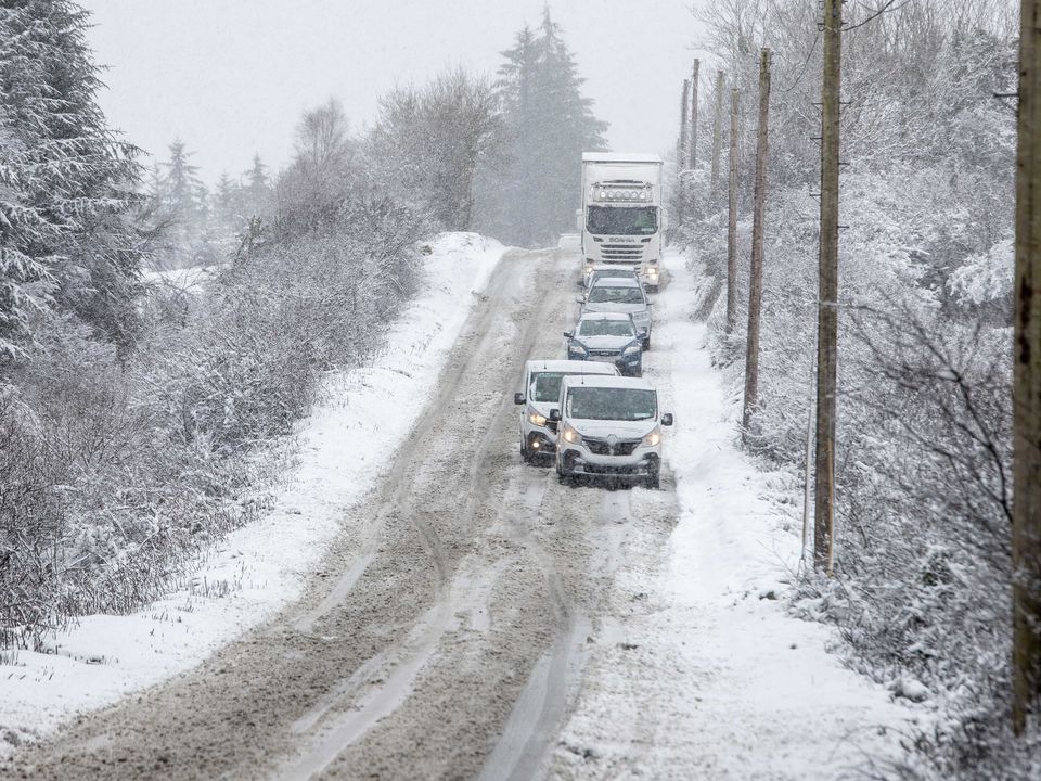 Cars, vans and a truck crawl through the snow in Co Clare. Photo: Press 22