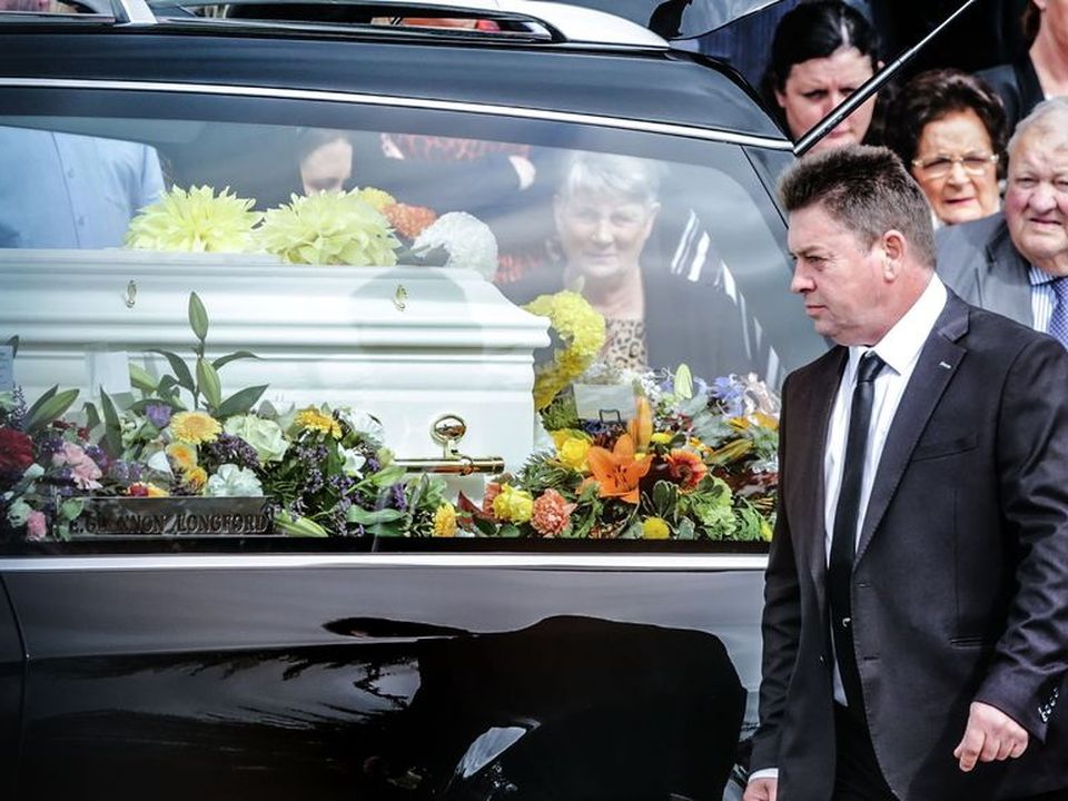 Michael Dennany looks on the coffin with his children Mikey and Thelma at their joint funeral last year. Photo: Gerry Mooney