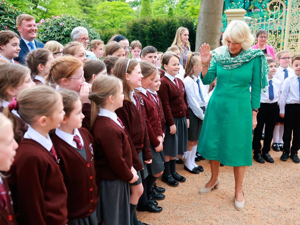 NEWTOWNABBEY, NORTHERN IRELAND - MAY 24: Queen Camilla greets school children during a visit to open the new Coronation Garden on day one of their two-day visit to Northern Ireland on May 24, 2023 in Newtownabbey, Northern Ireland. King Charles III and Queen Camilla are visiting Northern Ireland for the first time since their Coronation. Their Majesties will met designers of the Garden and representatives of community and charitable organisations, hearing how the Garden marks the beginning of a new green initiative for the Antrim and Newtownabbey Borough Council. (Photo by Chris Jackson/Getty Images)