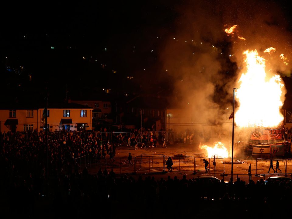 People gather at the burning of a bonfire in the Bogside area of Derry last month
