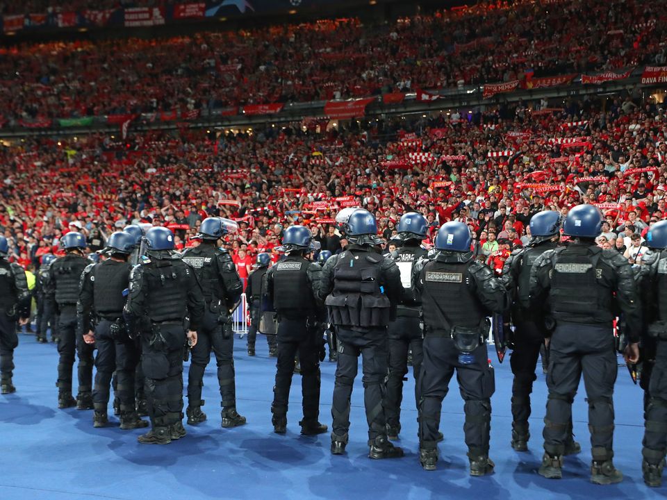 Riot police watch Liverpool supporters at the Stade de France.