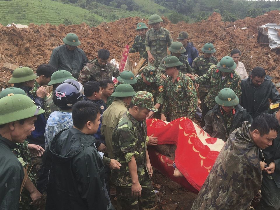 Army officers carry a body recovered from a landslide in Quang Tri province, Vietnam (Tran Le Lam/VNA/AP)