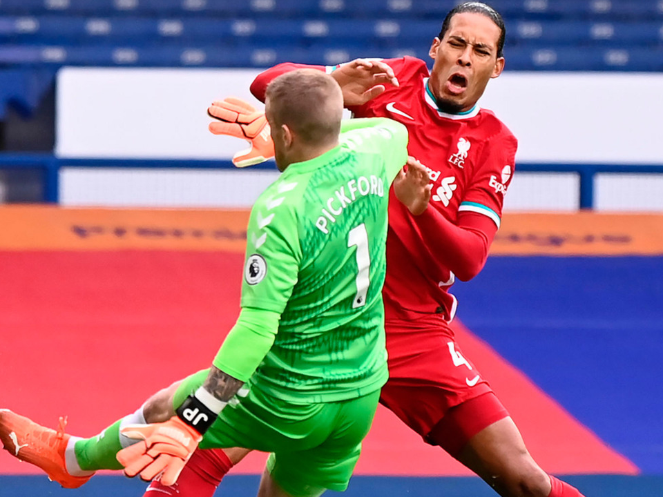 Liverpool's Virgil van Dijk (right) is challenged by Everton goalkeeper Jordan Pickford