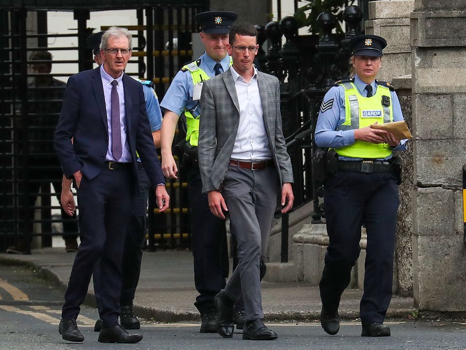 Burke (centre) is brought into the Four Courts accompanied by his father, Sean Burke