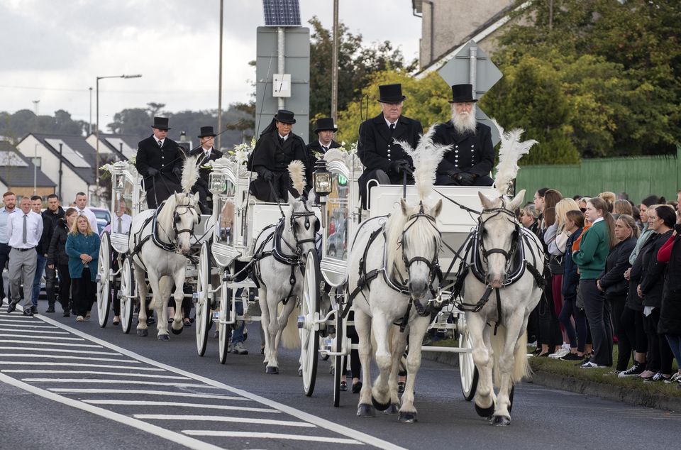Three horse drawn carriages carry the coffins to St Aidan's Church, Brookfield, Tallaght, for the removal of Lisa Cash and her twin siblings Chelsea and Christy Cawley.