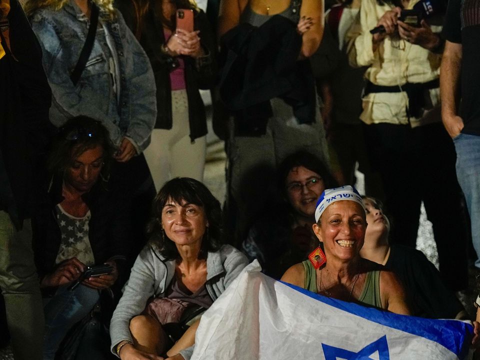 People react as they hear the news of the release of Israeli hostages (AP Photo/Ariel Schalit)