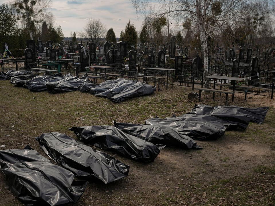 Bodies retrieved by municipal workers from the town are placed on the ground at a cemetery in Bucha, Ukraine, Thursday, April 7, 2022. (AP Photo/Vadim Ghirda)
