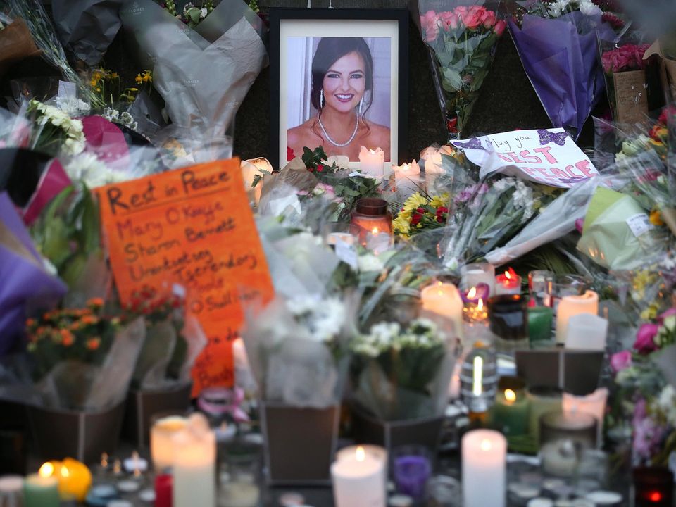 People pay their respects as flowers, messages and candles are left at a memorial outside Leinster House on Saturday for Ashling Murphy who was murdered in Tullamore on Wednesday evening. Photo: Stephen Collins/Collins Photos Dublin