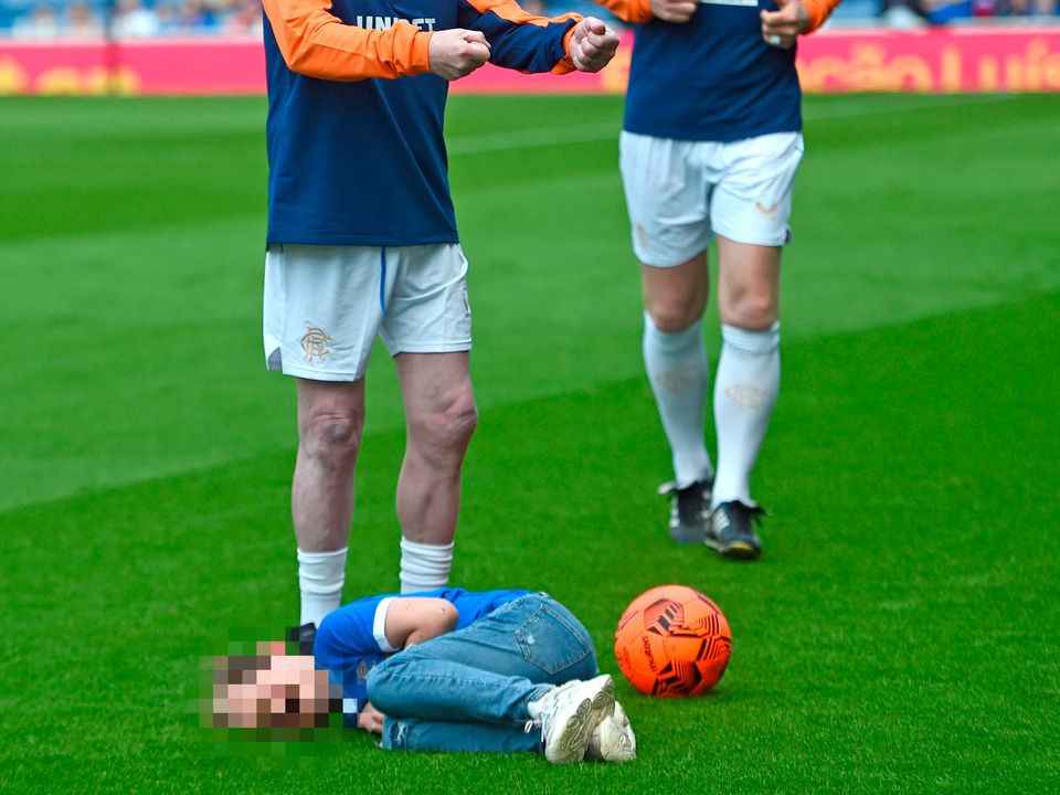 Rangers' Paul Gascoigne gestures after tripping up a ball boy before Rangers' 150th anniversary match at the Ibrox Stadium, Glasgow