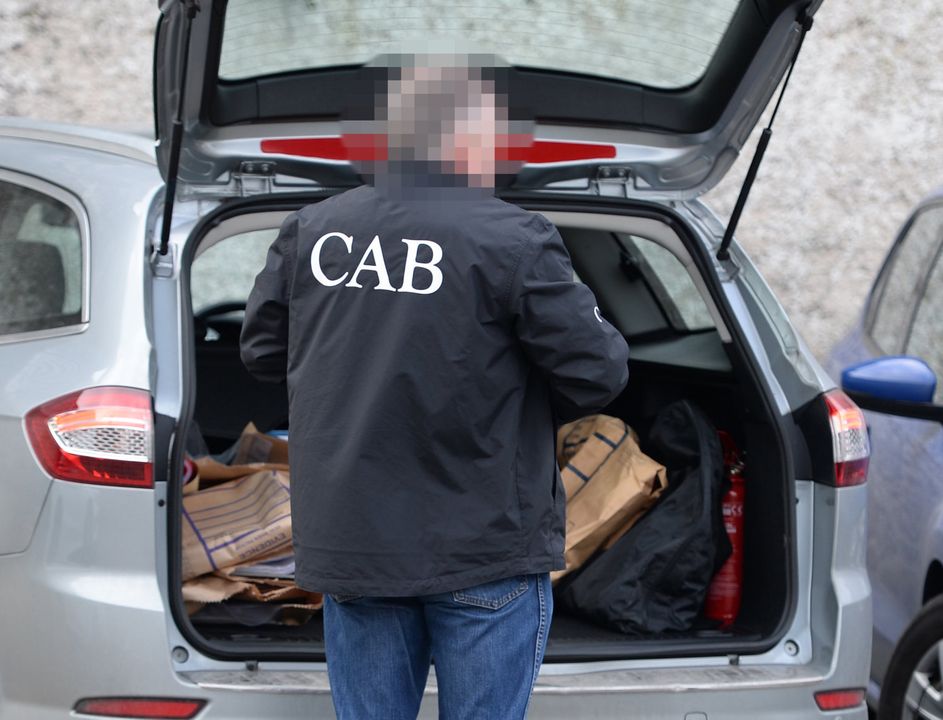 Search: A CAB officer collects items in a raid on Ross Browning’s property