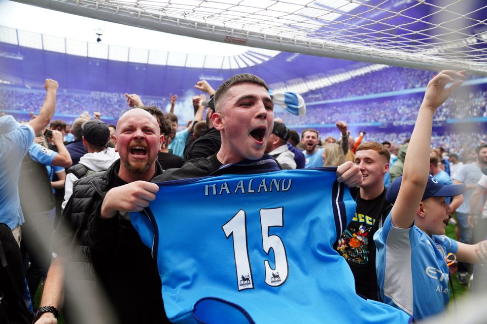 Manchester City fans invade the pitch after the 3-2 comeback win against Aston Villa secured the Premier League title (Martin Rickett/PA Images).