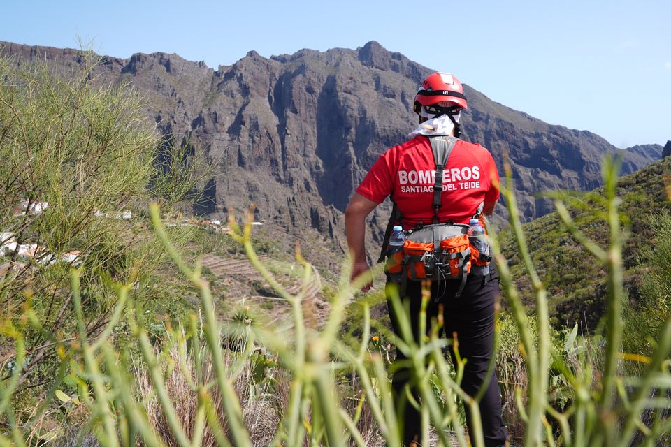 Firefighters look out over the village of Masca in Tenerife as the search for missing British boy Jay Slater, 19, continues (James Manning/PA)