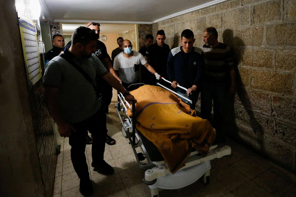 People push a stretcher with the body of Palestinian woman Ghada Sabatin