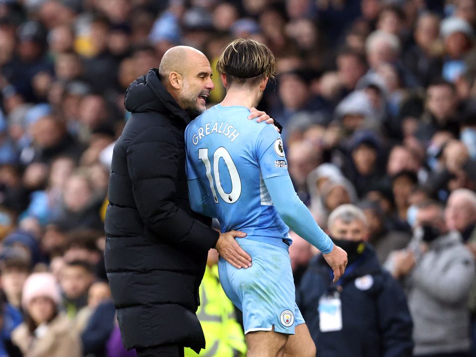 Manchester City's Jack Grealish (right) greets manager Pep Guardiola after he is substituted during the Premier League match at the Etihad Stadium, Manchester. Picture date: Saturday December 11, 2021.