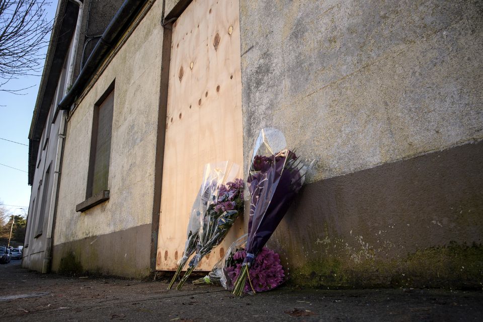 Flowers left outside the boarded-up vacant house on Beecher Street, Mallow, Co Cork where the body of Mr O'Sullivan was discovered. Photo: Daragh McSweeney