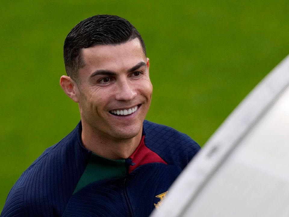 Cristiano Ronaldo smiles as he arrives for a Portugal training session yesterday. Portugal will play Nigeria Thursday in a friendly match in Lisbon before departing to Qatar on Friday for the World Cup. Photo: Armando Franca/AP Photo